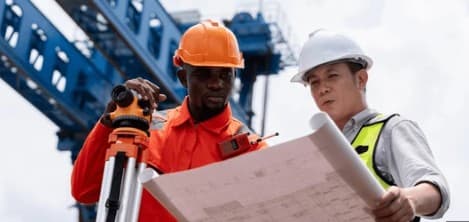 Construction surveyors reviewing blueprints on UAE project site